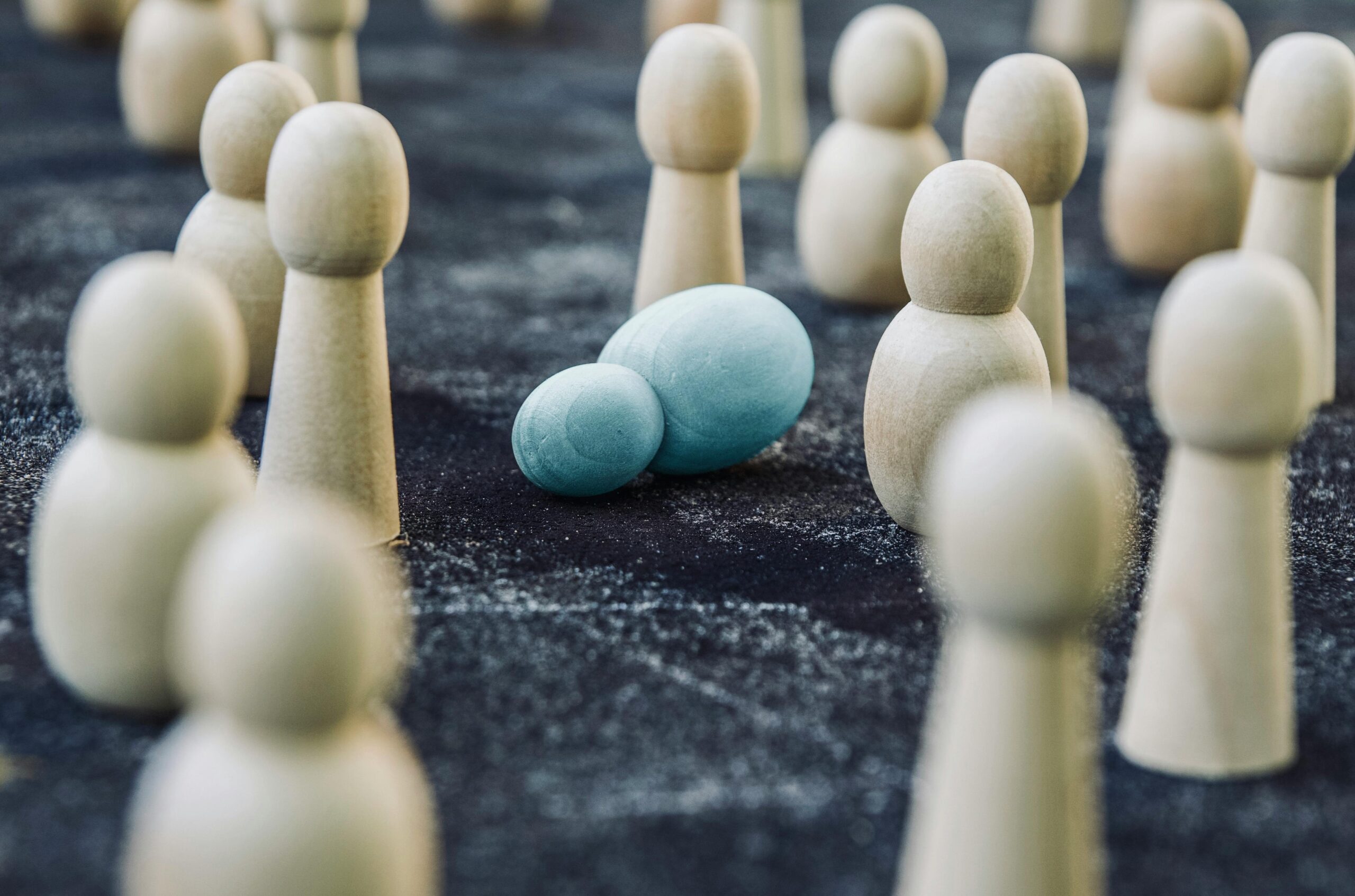 Wooden figures placed among fallen representing concept of breakdown during fight against public opinion and social order